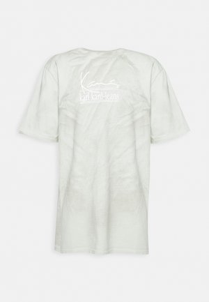 Helles grünes T-Shirt mit Rundhalsausschnitt aus weichem Material. Auf der Rückseite befindet sich ein weiß gedrucktes Logo "karl kani-jeans". Kurze Ärmel und lockere Passform.