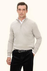 Grauer Wollpullover mit Reißverschluss am Kragen, kombiniert mit schwarzen Cordhosen. Verfügt über eine leichte Textur und eine taillierte Passform.