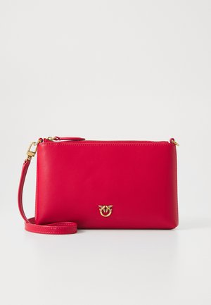 Piros bőr keresztbody táska sima textúrával, téglalap alakú, aranyszínű fémrészekkel és logóval az elülső részen. Állítható pánttal ellátva.