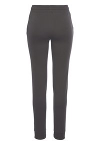 Graue, leichte Jogginghosen mit schmalem Bein, elastischem Bund und gerippten Bündchen. Glatte Textur ohne sichtbare Taschen oder Muster.