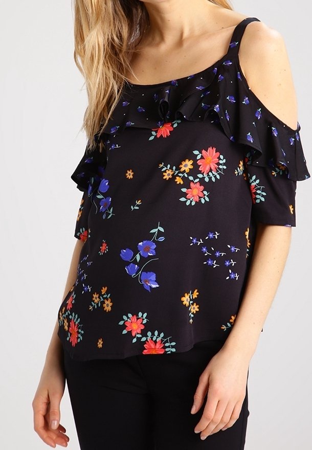Schwarzes Blumenshirt mit Rüschenausschnitt und schulterfreien Ärmeln, verziert mit bunten Blumen in Rot, Blau und Gelb auf weichem Stoff.