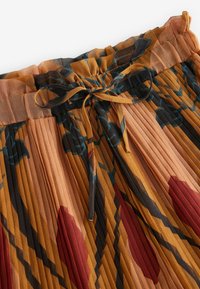 Pleated skirt in warm tones of orange and brown, featuring a floral pattern in dark green and red, with a drawstring waist for adjustment.