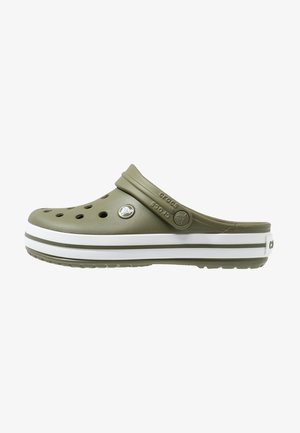 Oliwkowo-zielone klapki Crocs z otworami wentylacyjnymi, regulowanym paskiem na piętę i białą podeszwą z zielonymi paskami.