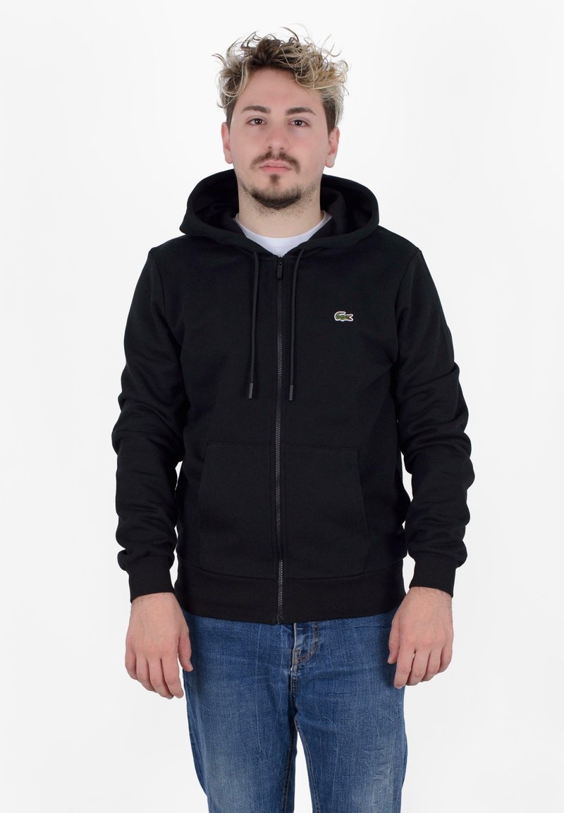 Sudadera negra con cremallera fabricada en una mezcla de algodón, con un bolsillo canguro, capucha con cordón y un pequeño logo bordado en el lado izquierdo del pecho.