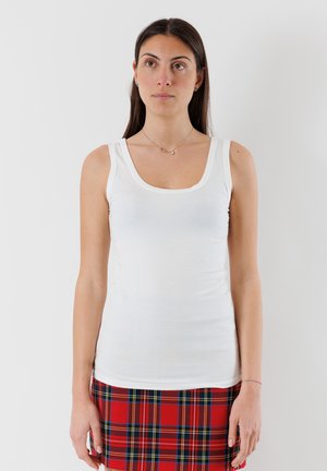 Top senza maniche bianco con scollatura rotonda e design aderente, abbinato a una gonna a quadri rossa. Tessuto morbido e materiale leggero.