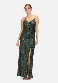 Grünes Pailletten-Abendkleid mit tiefem V-Ausschnitt, dünnen Trägern und einem hohen Schlitz bis zum Oberschenkel. Bodentiefe Ausführung mit figurbetontem Schnitt und schimmernder Textur.