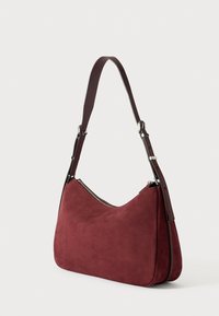 Burgundska zamjena torba od kože s zakrivljenim oblikom, podesivim tamnoljubičastim kožnim remenom, srebrnim zatvaračem i glatkom teksturom. Idealna za svakodnevnu upotrebu.