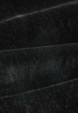 Samtstoff in tiefem Schwarz, der eine glatte Textur mit leichtem Glanz und sanften Falten zeigt, wodurch subtile Licht- und Schattenvariationen entstehen.