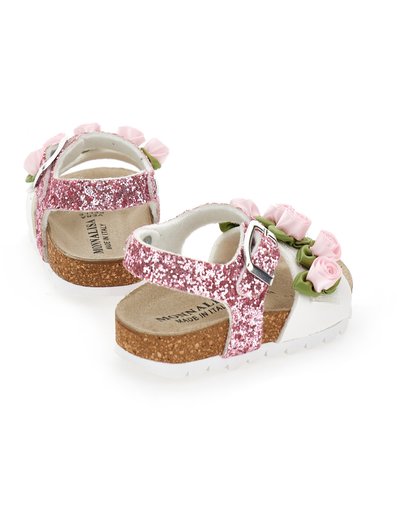 Sandalias rosa brillantes con tiras blancas, suela de corcho, adornos florales, hebilla ajustable, plantilla texturizada, diseño redondeado.