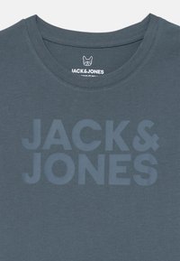 Σκούρο μπλε βαμβακερό t-shirt με στρογγυλή λαιμόκοψη, που διαθέτει μια μεγάλη, τονική γραφική απεικόνιση "JACK & JONES" στο μπροστινό μέρος. Λείο υλικό.
