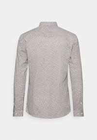 Camisa de manga larga en una tela ligera, con un patrón geométrico en colores apagados, con un cuello alzado y detalles de botones.