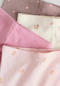 Fyra par leggings i rosa, ljuskräm och brunt, med hjärt- och blommönster, tillverkade av mjukt, elastiskt stickat tyg.