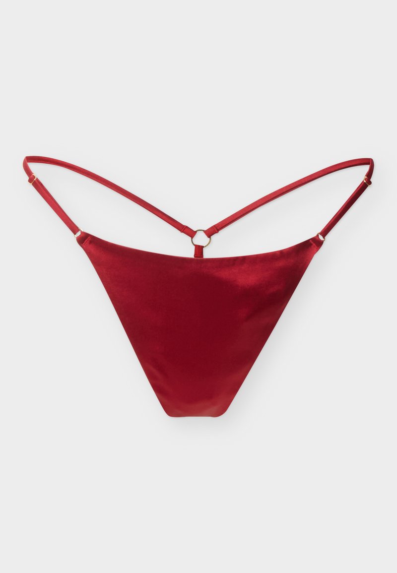 Κόκκινο σατέν στρινγκ εσώρουχο με λεπτές ρυθμιζόμενες τιράντες και έναν μικρό κεντρικό μεταλλικό κρίκο που συνδέει τις τιράντες στο πίσω μέρος.