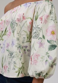 Off-shoulder bluse i lett stoff med blomstermønster i rosa, lilla og grønne nyanser; rynkede elastiske ermer; glatt finish.