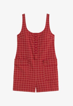 Combinaison rouge sans manches avec un col dégagé, une patte de boutonnage sur le devant et deux grandes poches plaquées avant avec rabats.