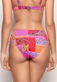 Tvådelad baddräkt med ett lapptäckesdesign i rosa, orange och lila nyanser, med paisleymönster och prickar. Justerbara band ingår.