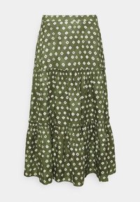 Grönmönstrad kjol i lättviktigt tyg, med ett lager-på-lager-design som har vita diamantformer och en rynkad fåll.