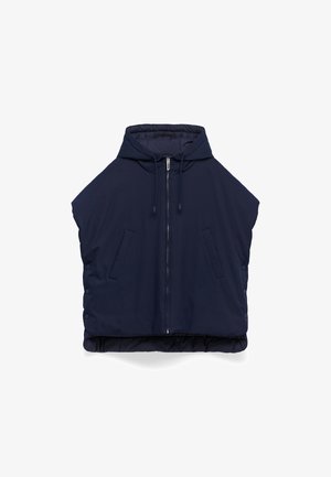 Veste matelassée bleu marin avec un col haut, fermeture éclair et deux poches avant. Dotée de boutons-pression sur les côtés et d'un design légèrement court.