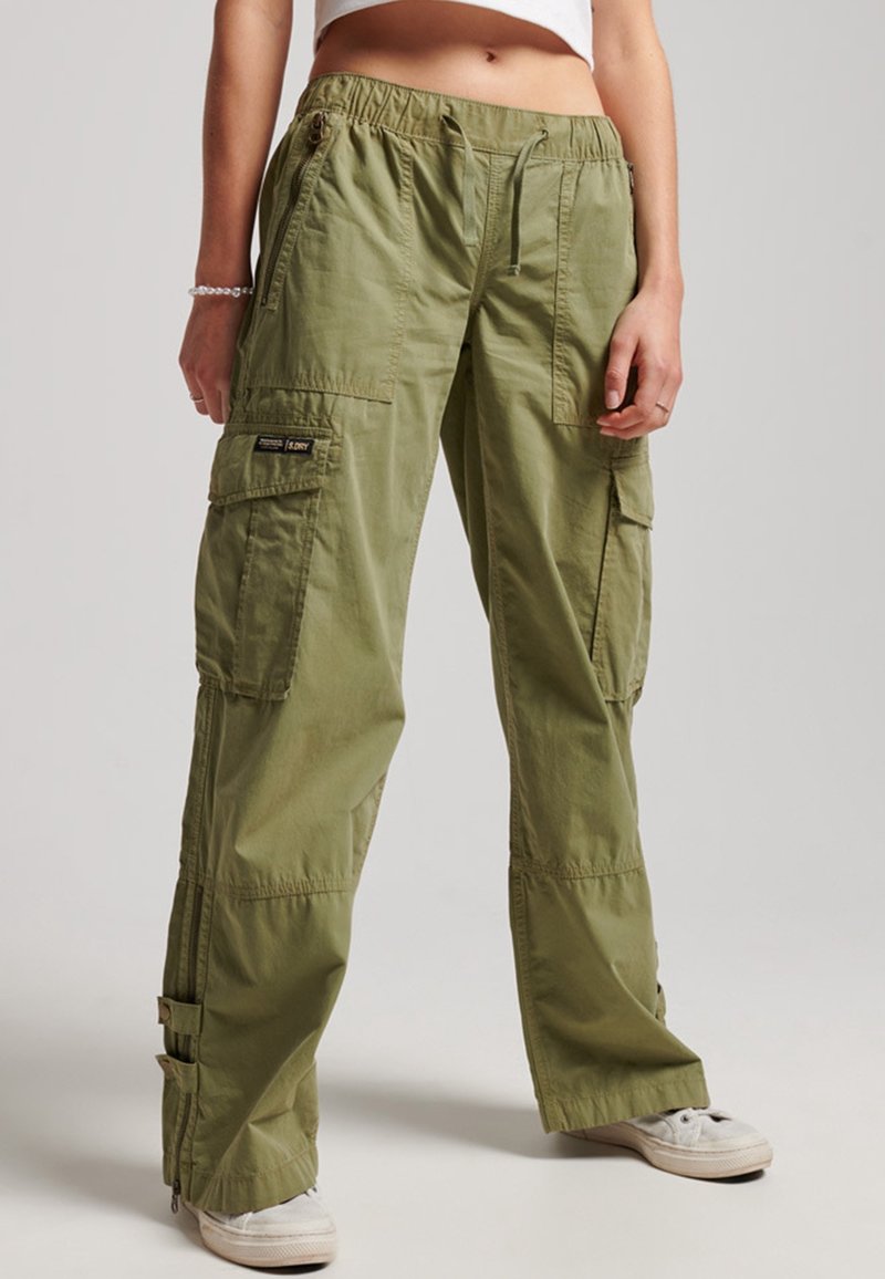 Pantalon cargo vert olive avec taille élastique, multiples poches et fermetures éclair à l'ourlet ; fabriqué en tissu léger et texturé.