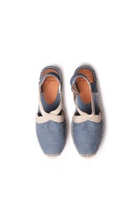 Espadrilles de lona azul con acentos de tela beiges, tiras cruzadas, suela de yute y detalles cosidos. La suela tiene un acabado texturizado.