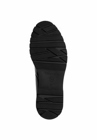 Semelle de chaussure en caoutchouc noir avec une texture adhérente, présentant un motif en zigzag et le nom de marque gravé "Tamaris" ainsi que la taille "37".