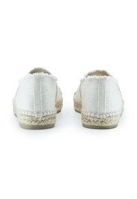 Espadrillas bianche in tela di juta con bordi sfilacciati, suole in corda di juta e parte superiore testurizzata. Forma arrotondata con design slip-on, stile minimalista.