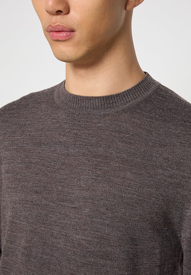 Suéter marrón de punto con un escote redondo acanalado, fabricado en un material suave, con una textura sutil y una silueta ajustada.