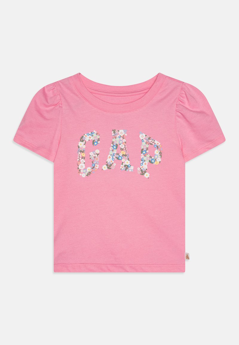 Lyserød kortærmet T-shirt med puffede ærmer, der har ordet "GAP" i blomsterprint med små multikolorede blomster. Blødt bomuldsmateriale.