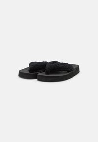 Black flip-flops with textured rubber soles and fuzzy, looped black straps. Simple design, lightweight construction, and comfortable fit.