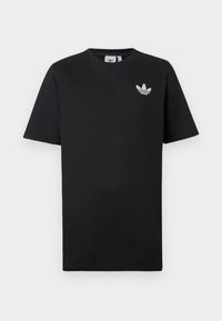 Černé bavlněné tričko s krátkým rukávem a kulatým výstřihem. Na levé části hrudi je malé bílé logo Adidas.