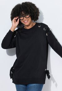 Černá mikina s dlouhým rukávem se stříbrnými oky a zavazovacími detaily na ramenou a bocích, s pohodlným střihem a měkkou texturou.