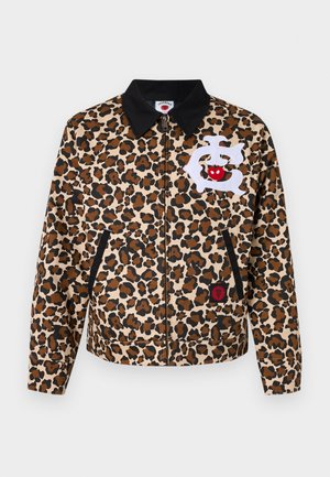 Veste imprimée léopard en marron et noir, avec un col noir, une fermeture éclair à l'avant et un patch décoratif blanc avec des accents rouges.