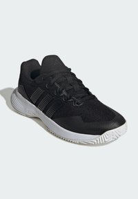 Czarne buty sportowe z teksturowaną cholewką, systemem sznurowania i trzema poziomymi paskami. Biała gumowa podeszwa z wzorem bieżnika.
