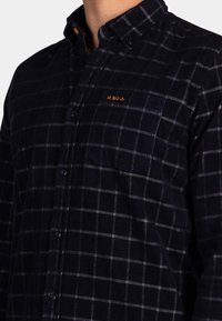 Marine geruite overhemd met knopen, gemaakt van gestructureerde stof, met witte rasterlijnen, een borstzak en een oranje geborduurd logo.