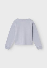 Svetlo siva kratka majica sa zaobljenim izrezom, dugim rukavima i rebrastim manžetama. Glatka tekstura s minimalnim dizajnerskim detaljima.