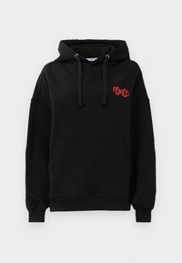 Sweatshirt preto com capuz, bolso frontal, cordões, punhos canelados e pequeno texto vermelho "Fiorucci" no lado superior esquerdo do peito.