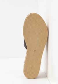 Semelle de sandale avec texture côtelée beige et numéro de taille 37 embossé, positionnée à la verticale contre un fond blanc en angle.