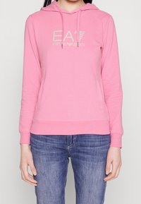 Felpa con cappuccio rosa caratterizzata da una tasca frontale, logo EA7 ricamato e polsini e orlo a coste. Tessuto morbido con una superficie liscia.