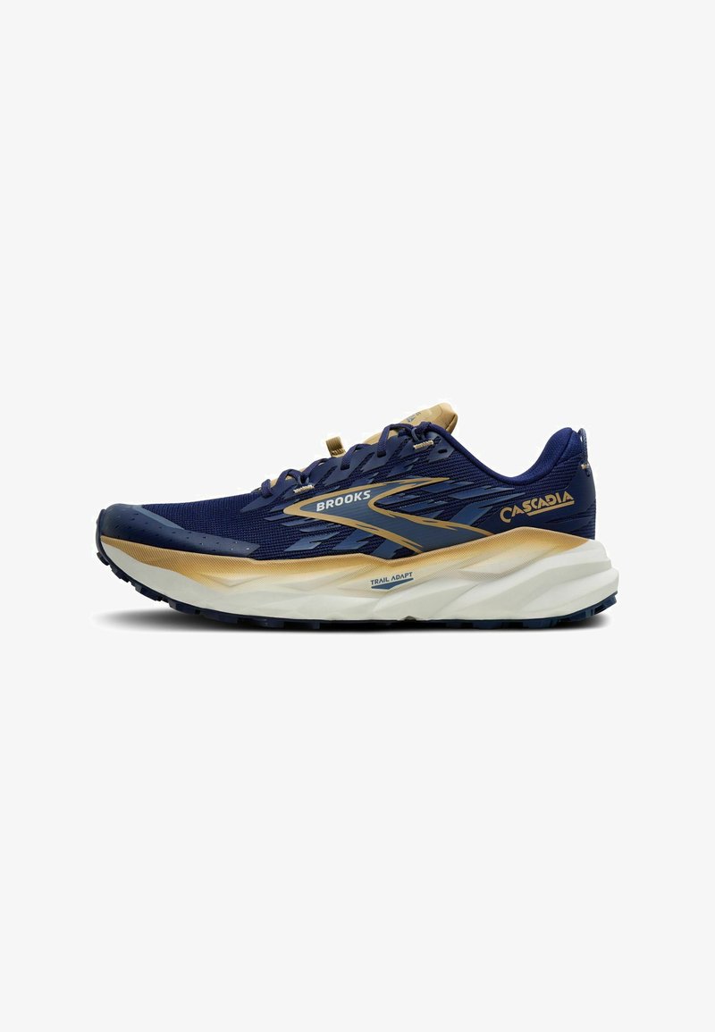 Scarpa da trail running Brooks Cascadia blu navy e beige con suola bianca, tomaia in mesh, design con lacci e marchio sul lato e sul tallone.