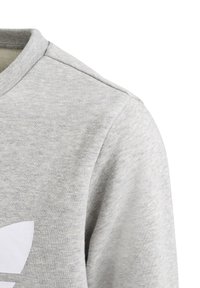 Šedá mikina s kulatým výstřihem, vyrobená z měkké, texturované látky. Na přední straně je velké bílé logo.