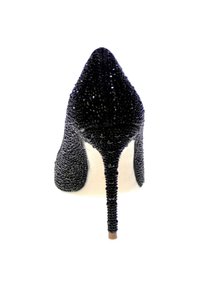 Scarpa con tacco alto nera e punta affilata, decorata con dettagli testurizzati. Il tacco a stiletto è sottile e affusolato, in contrasto con la suola liscia.