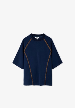 Marineblauw shirt met korte mouwen en oranje zigzagstiksels langs de raglannaden en een rechte zoom, met een ronde hals.