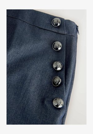 Denim nederdel i en mørkeblå stof, med en glat tekstur og fem blanke, dekorative knapper langs siden. Lynlås lukning bagpå.
