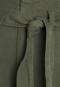 Tissu vert olive à texture lisse, doté d'une ceinture nouée. Le matériau semble doux, avec des coutures visibles le long des bords.