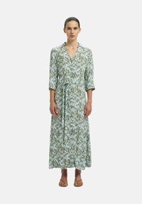 Robe longue à motifs floraux verts et bleu clair avec un col, une taille à nouer et des manches trois-quarts. Tissu lisse avec une silhouette fluide.