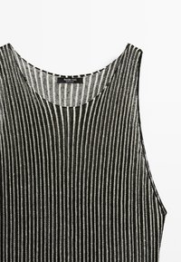 Top senza maniche a righe bianche e nere con scollatura arrotondata, con l'etichetta del marchio "Massimo Dutti" vicino al collo.