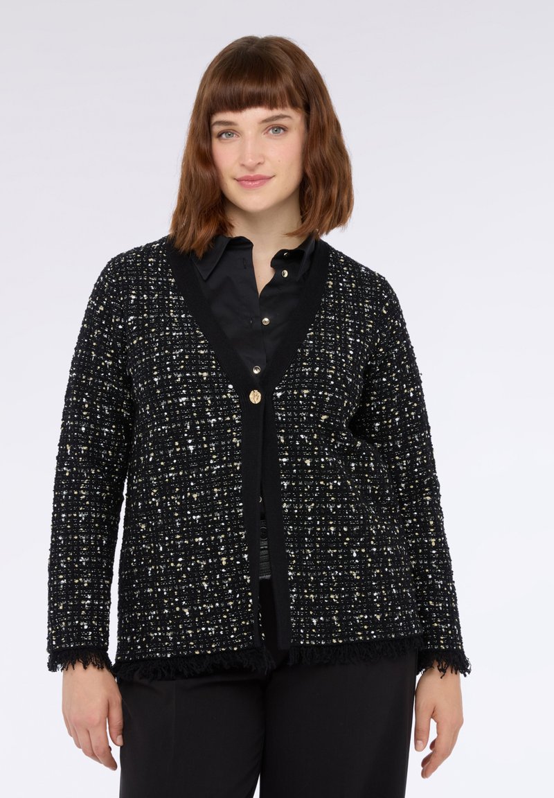 Schwarze Strickjacke mit einem strukturierten Muster aus metallischen Fäden. V-Ausschnitt-Design, eine Knopfverschluss und fransige Saumakzente.