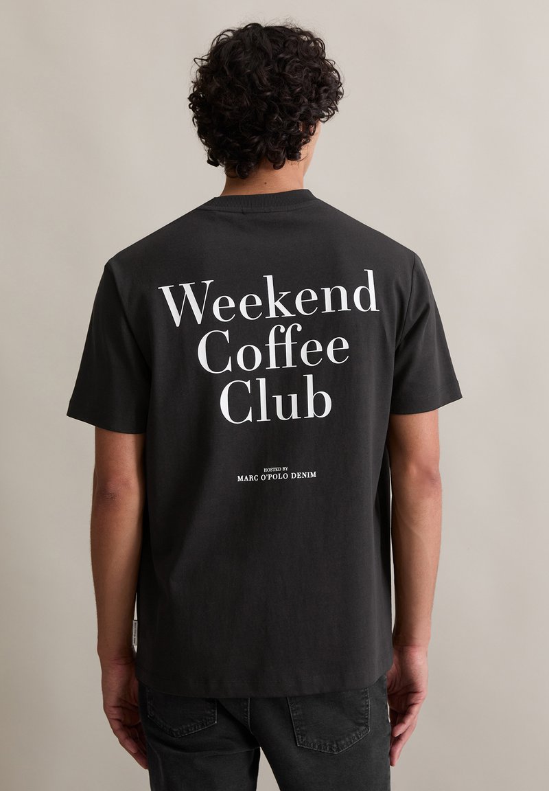 Zwarte katoenen t-shirt met korte mouwen, voorzien van grote witte tekst op de achterkant: "Weekend Coffee Club" met "georganiseerd door Marc O'Polo Denim."