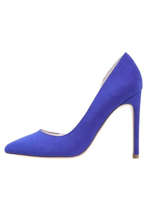 Zapato de salón femenino de tacón alto en ante azul, con punta afilada y tacón de aguja delgado, vista lateral sobre fondo blanco.
