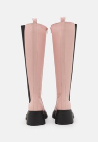 Bottes hautes en matériau synthétique rose et noir. Présentent un design élégant, des fermetures éclair arrière et une semelle noire épaisse. Surface texturée avec des détails de couture.